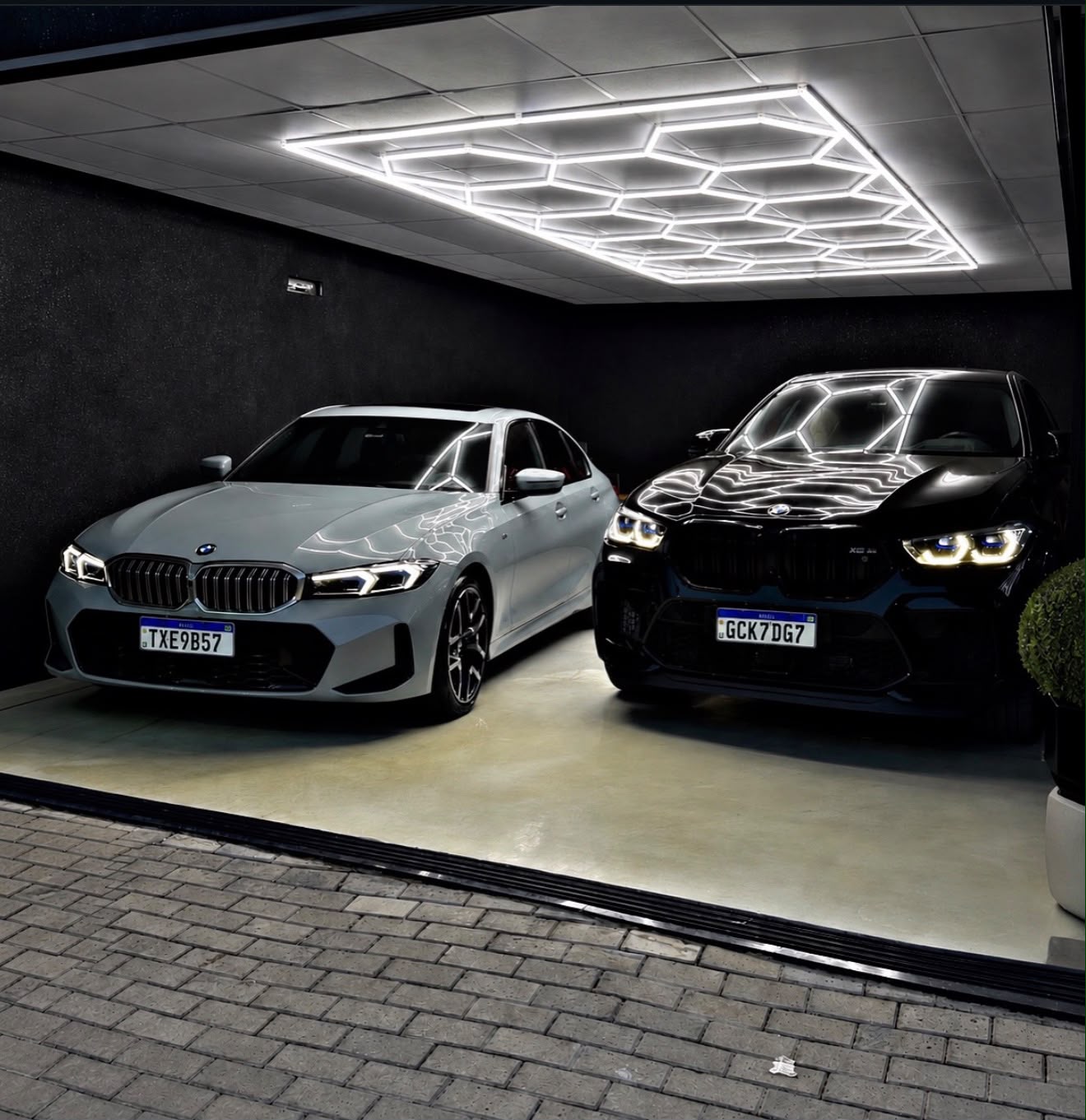 BMW X6 M e Série 3 na garagem iluminada